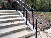 Commercial staircase railing and fence-line metalwork.