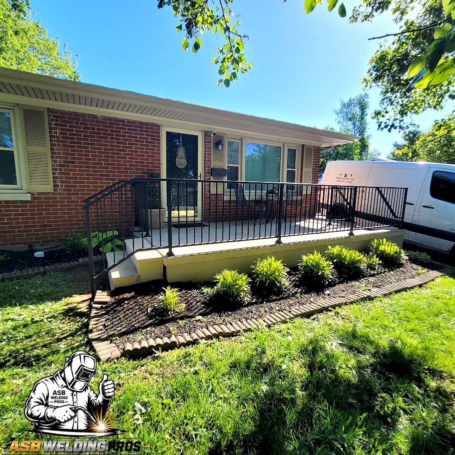 Black welded access-ramp railing installed beside a Central Kentucky brick home.