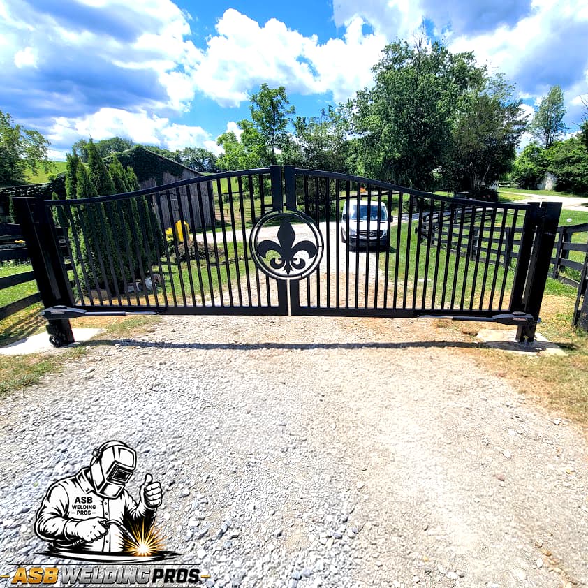 Black driveway gate with a custom fleur-de-lis center panel.