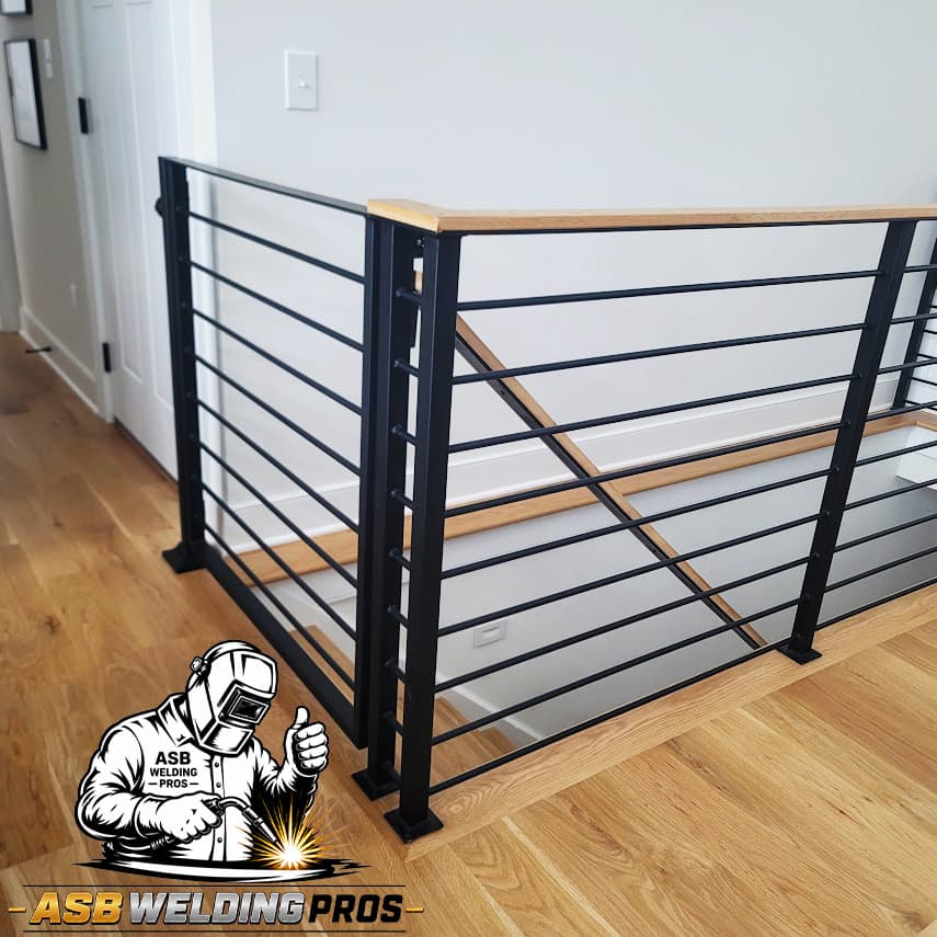 Modern black horizontal guardrail installed along an interior staircase.