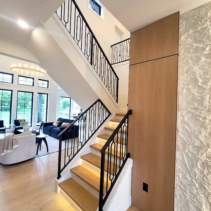 Black metal stair railing installed in an open-plan residential interior.