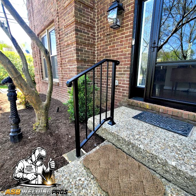 Compact black entry handrail installed on a small residential stoop.