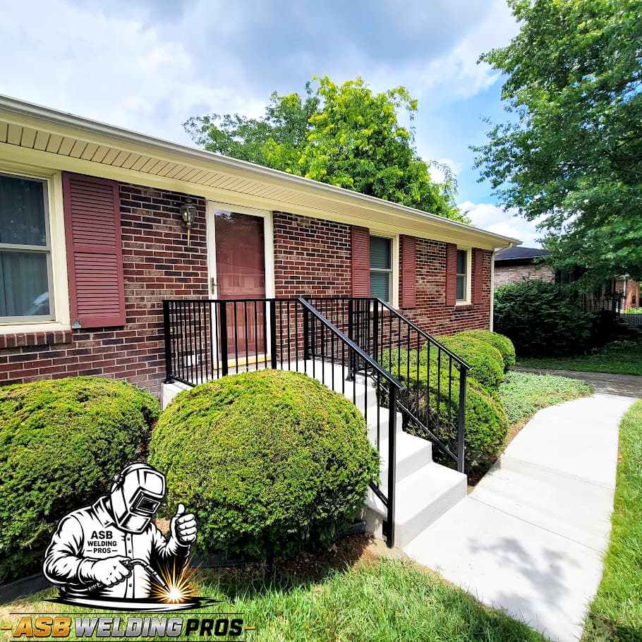 Black metal entry railing installed along the steps of a brick home.