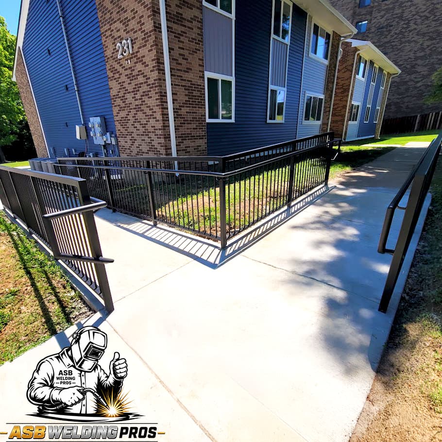 Black perimeter railing and pedestrian gate enclosing a residential patio.