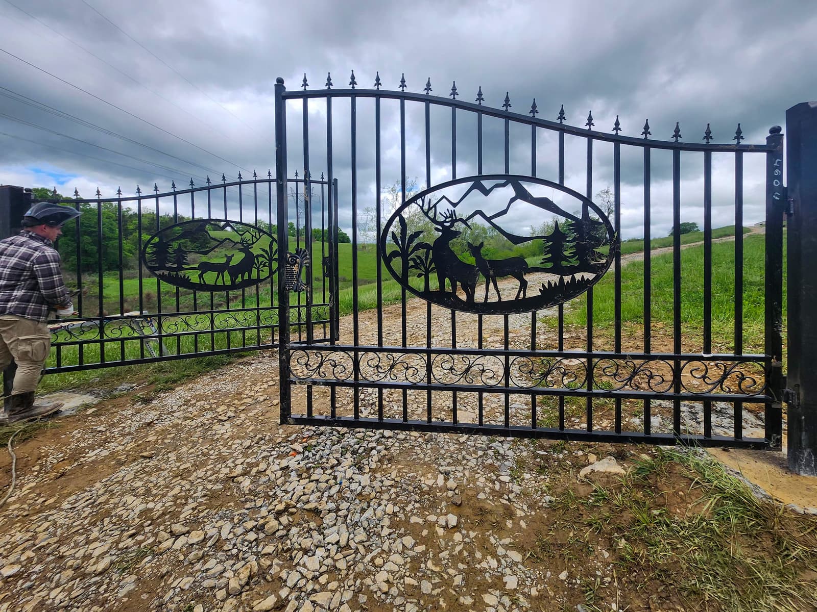 Large ornamental metal swing gate installed at a wide property entry.