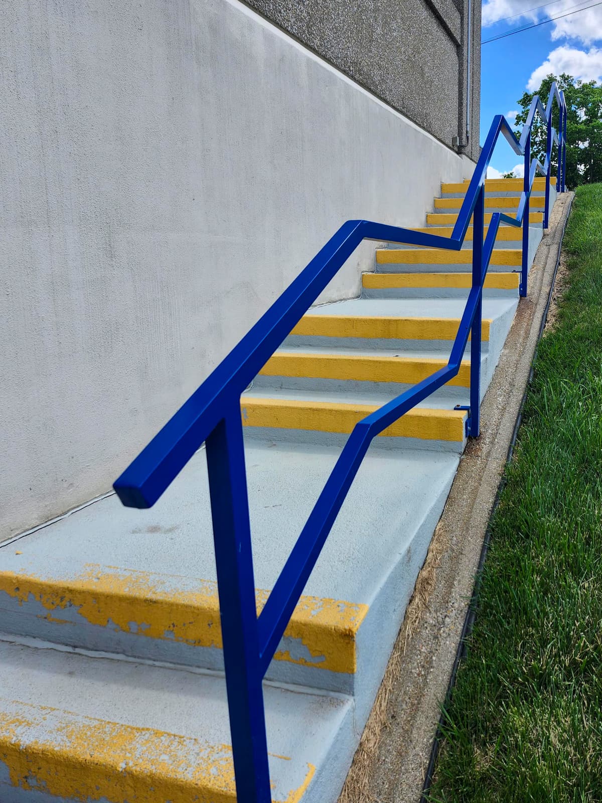 Blue commercial stair handrail installation for a Central Kentucky access path.