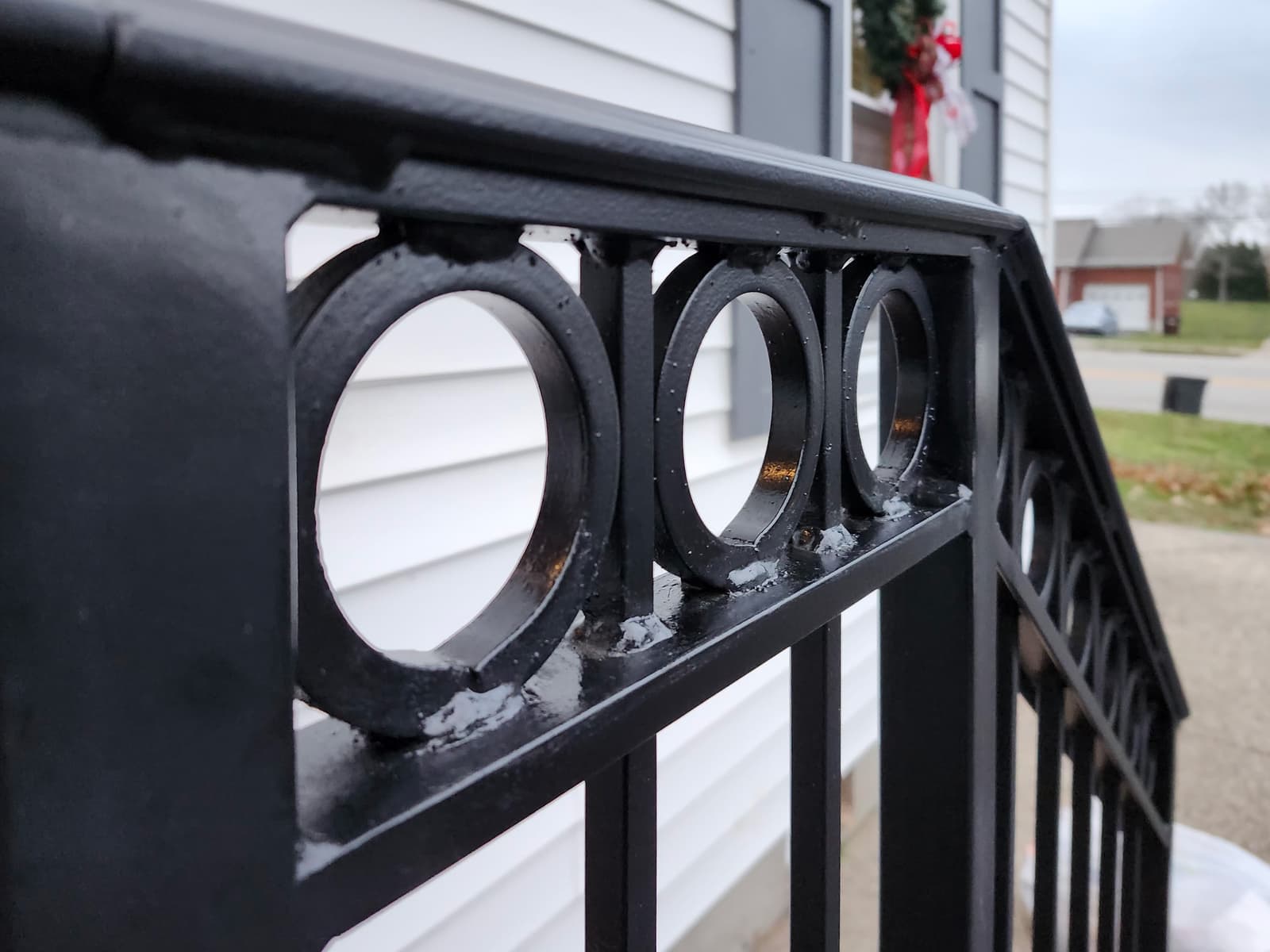 Ornamental porch railing with black metal finish.